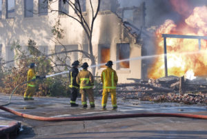 Four fire men taking control of a building fire
